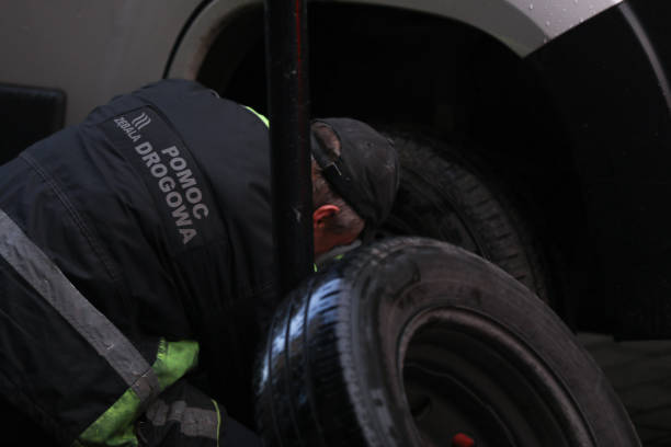 worker changes a tire on a car on the street