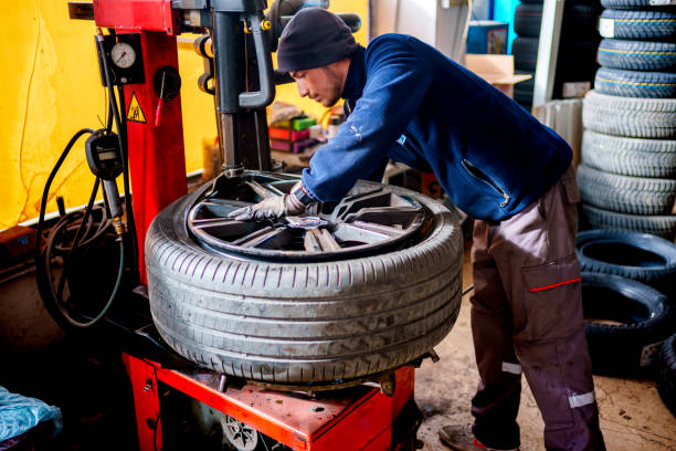 Mechanic changing tire in car service.